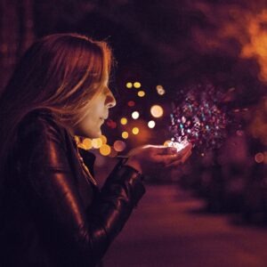 woman blowing sprinkle in her hand